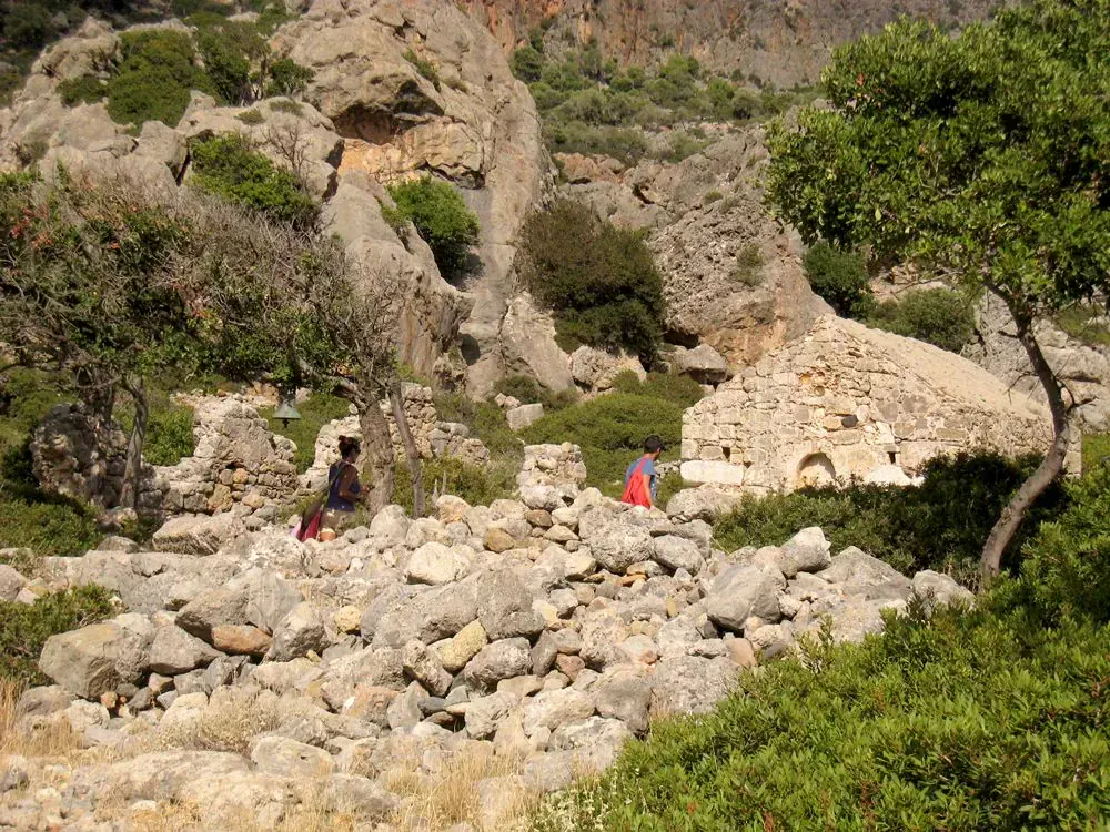 Hikers exploring ruins of Panagia chapel in Lissos gorge - Crete - Greece