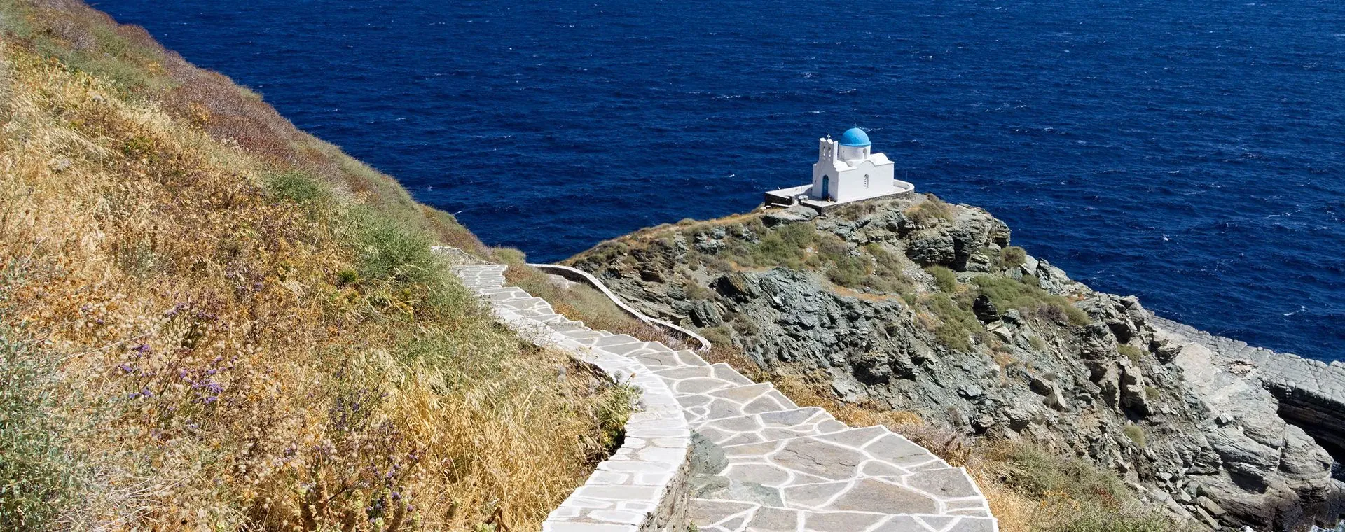 Chemin dallé menant à la chapelle Eftamartyres au dôme bleu sur la falaise - Sifnos - Grèce