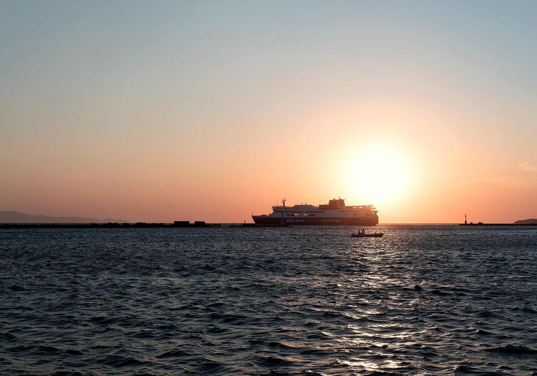 Ferry quittant un port des Cyclades au coucher du soleil - mer Égée - Grèce © Jules Verne Times Two / Wikimedia (CC BY-SA 4.0)