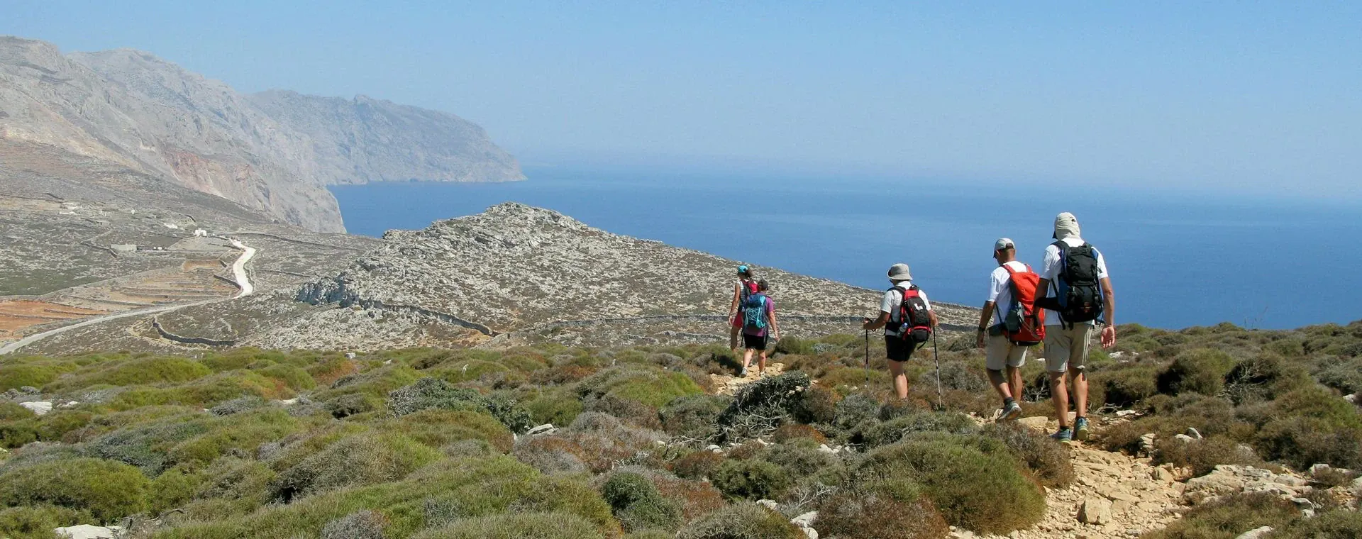Randonneurs sur un sentier côtier dominant la mer Égée - Île d'Amorgos, Grèce