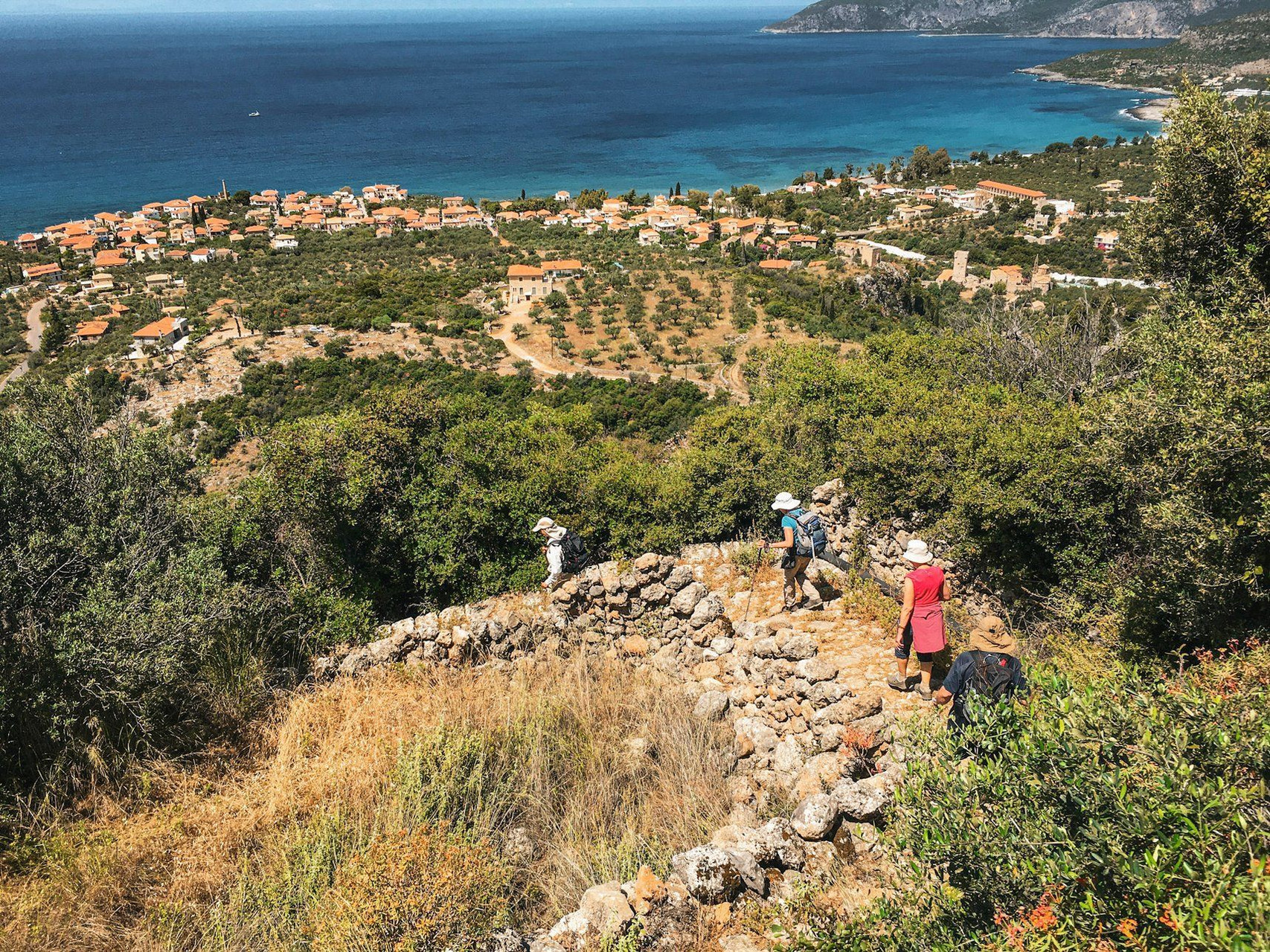 Randonneurs sur un sentier de pierre face à la mer - Péloponnèse - Grèce