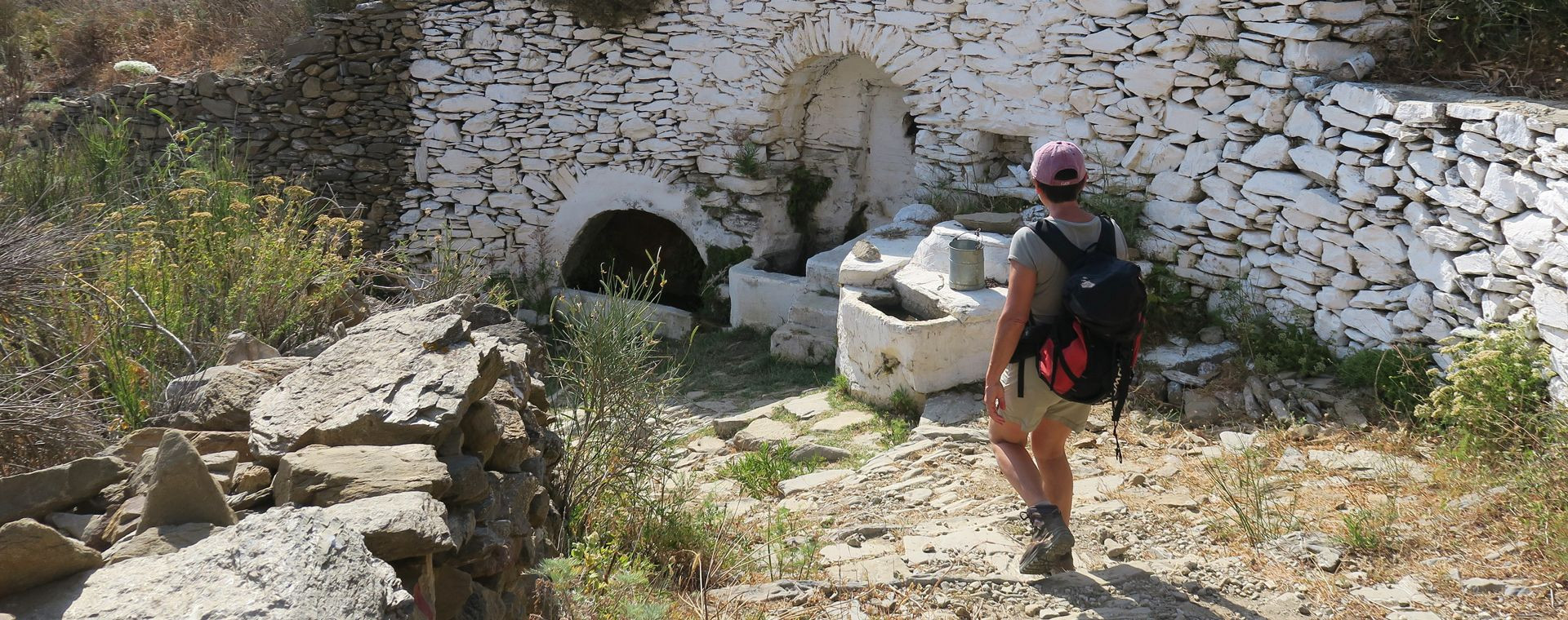 Randonneur près d'une fontaine en pierre - Amorgos - Grèce