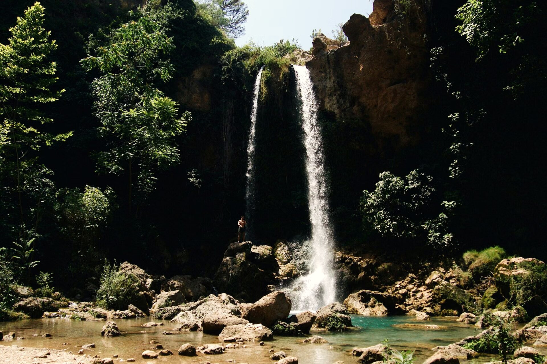 Cascade se jetant dans un bassin d'eau claire au fond d'une gorge boisée - Crète, Grèce