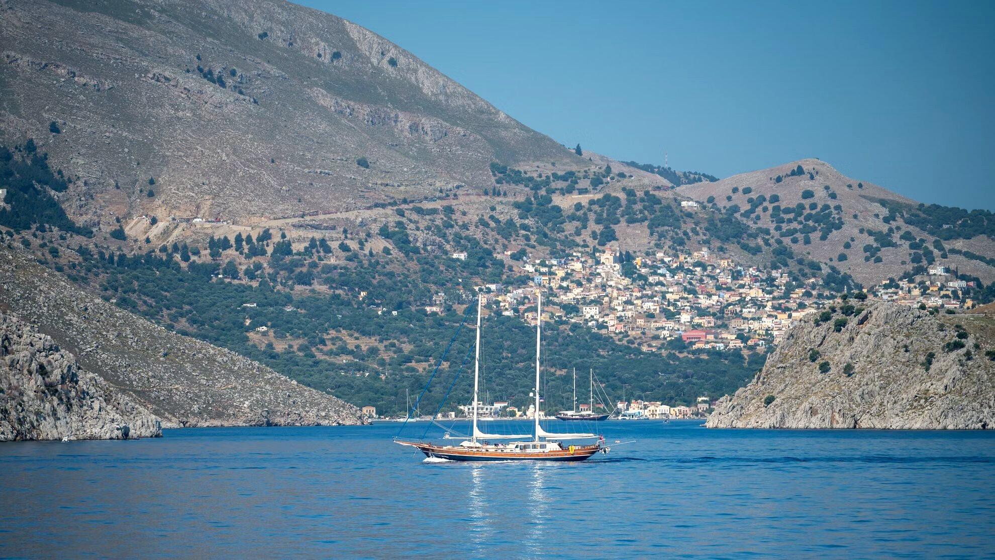 Voilier ancré dans une baie au pied des falaises - Symi - Grèce