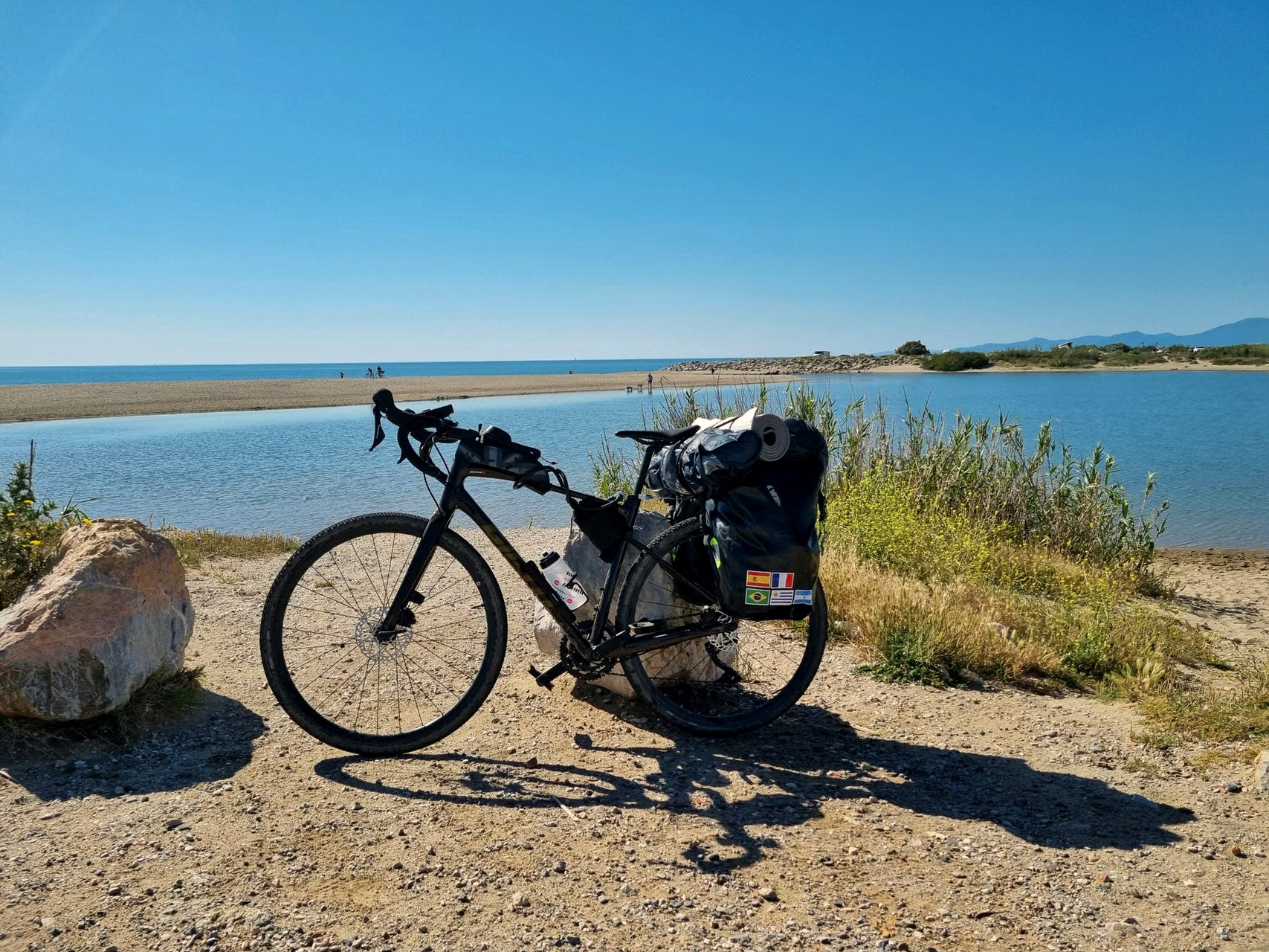 Vélo de voyage chargé sur une route côtière - Grèce